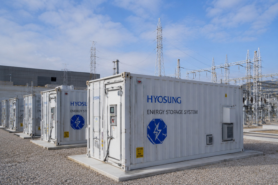 Hyosung Heavy Industries is expanding its energy storage system (ESS) business in Japan as demand for renewable energy infrastructure and grid stabilization accelerates across Asia. The image illustrates a large-scale ESS facility integrated with high-voltage power infrastructure.  Illustration by Yeon Chulwoong based on Hyosung Heavy Industries materials