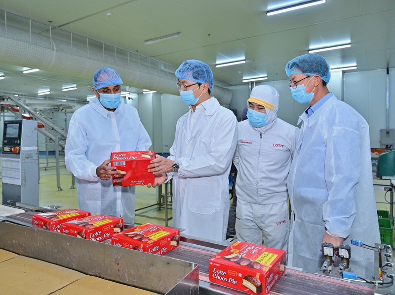Lotte Wellfood CEO Lee Chang-yup (second from left) inspects a Choco Pie production line at the company’s Haryana plant in India. Lotte Wellfood’s overseas subsidiaries posted a 28% increase in revenue and a 133% surge in operating profit in the second quarter, supported by growth in India.  Courtesy of Lotte Wellfood