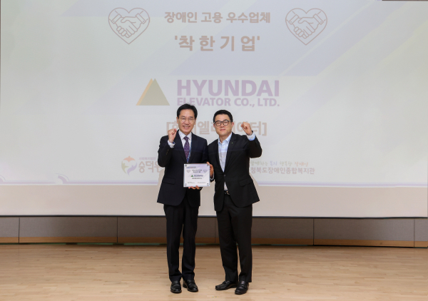 안지훈 현대엘리베이터 인사담당(사진 오른쪽)과 이준호 사회복지법인 숭덕원 이사가 7일 충주 유네스코 국제무예센터에서 열린 ‘착한기업’ 현판 수여식을 마친 뒤 기념 촬영을 하고 있다/ 현대엘리베이터 제공